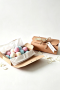 2 Kraft boxes one open with with 20 mini multi colours of round bath bombs next to in the closed packaged box with Hemp ribbon and a thank you label very rustic item on a white background 